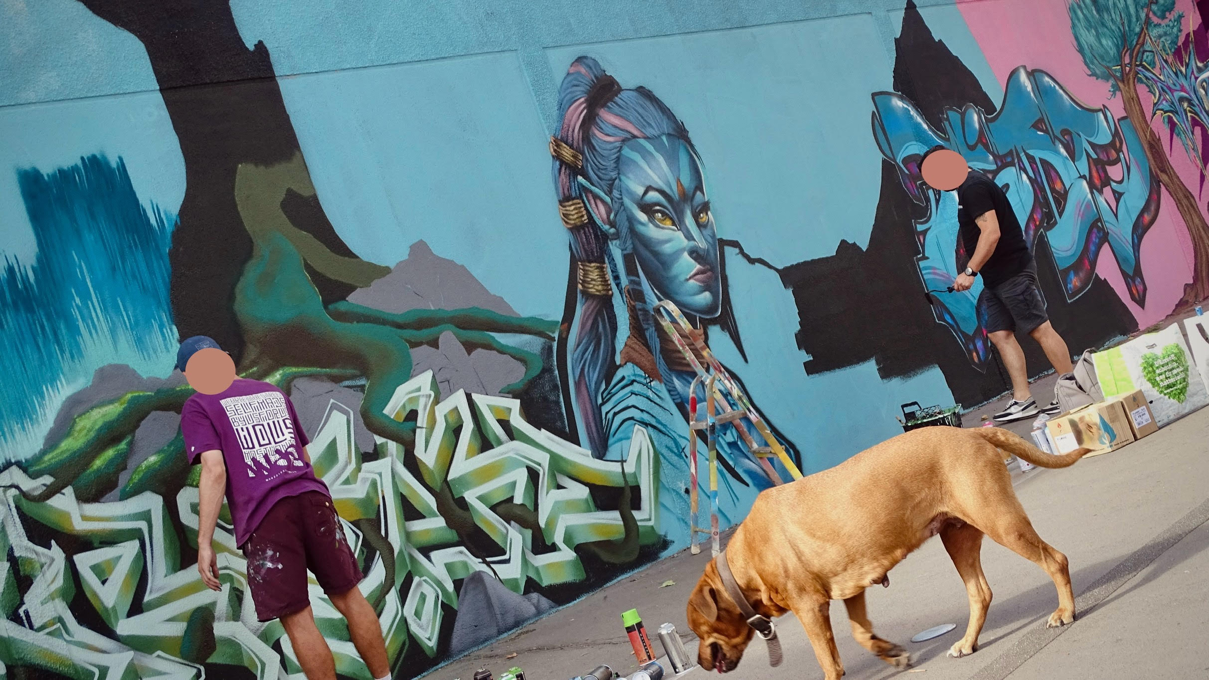 Vue large d’une fresque murale Avatar avec portrait et graffiti en cours de réalisation