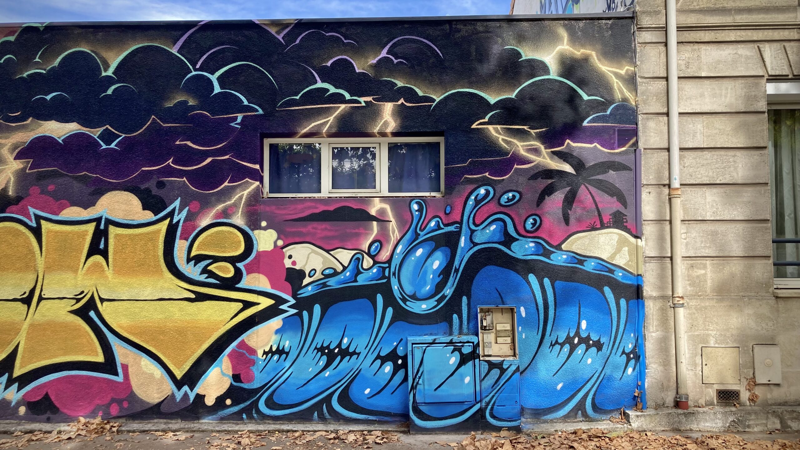 Fresque graffiti représentant une vague stylisée avec ciel orageux.