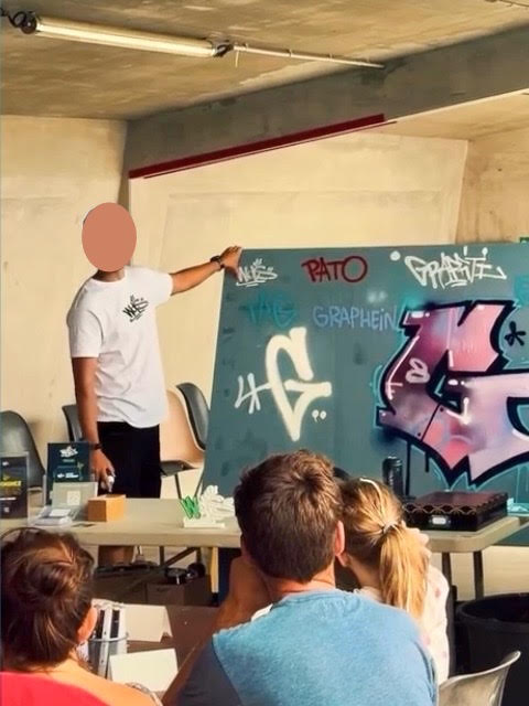 Démonstration de techniques de graffiti par WOLS Street Art devant les participants d’un atelier CAP33 à Floirac.