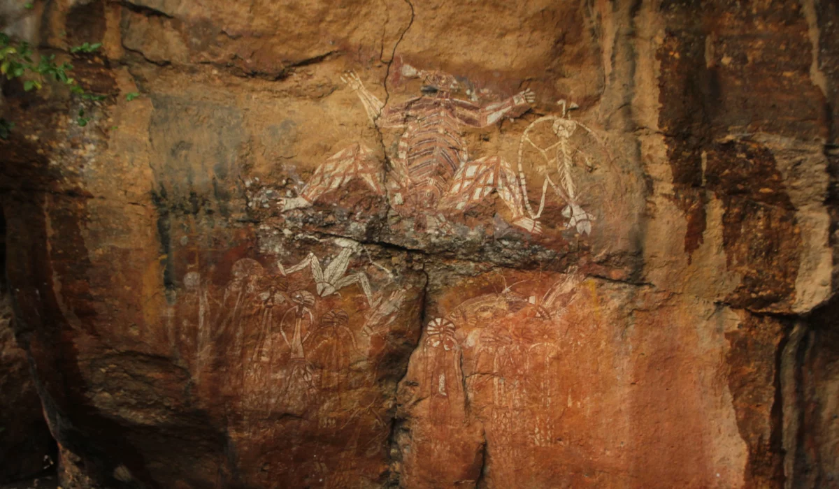 Peintures rupestres anciennes représentant des personnages et des scènes figuratives sur une paroi rocheuse.
