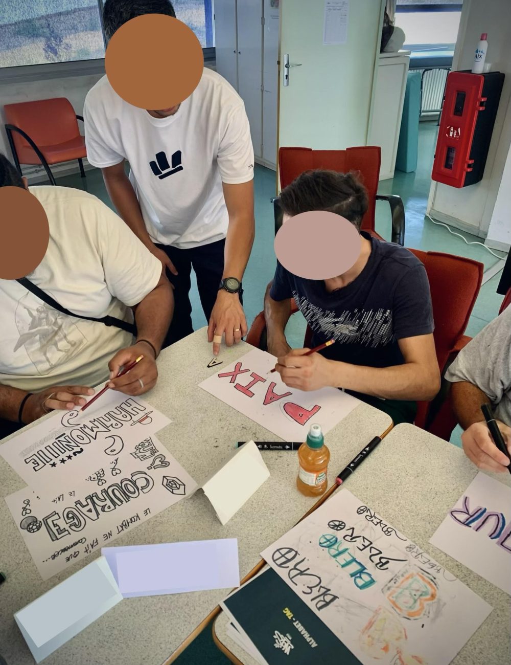 Participants dessinant leurs lettrages pendant un atelier graffiti à la Clinique des Gravières à Lormont