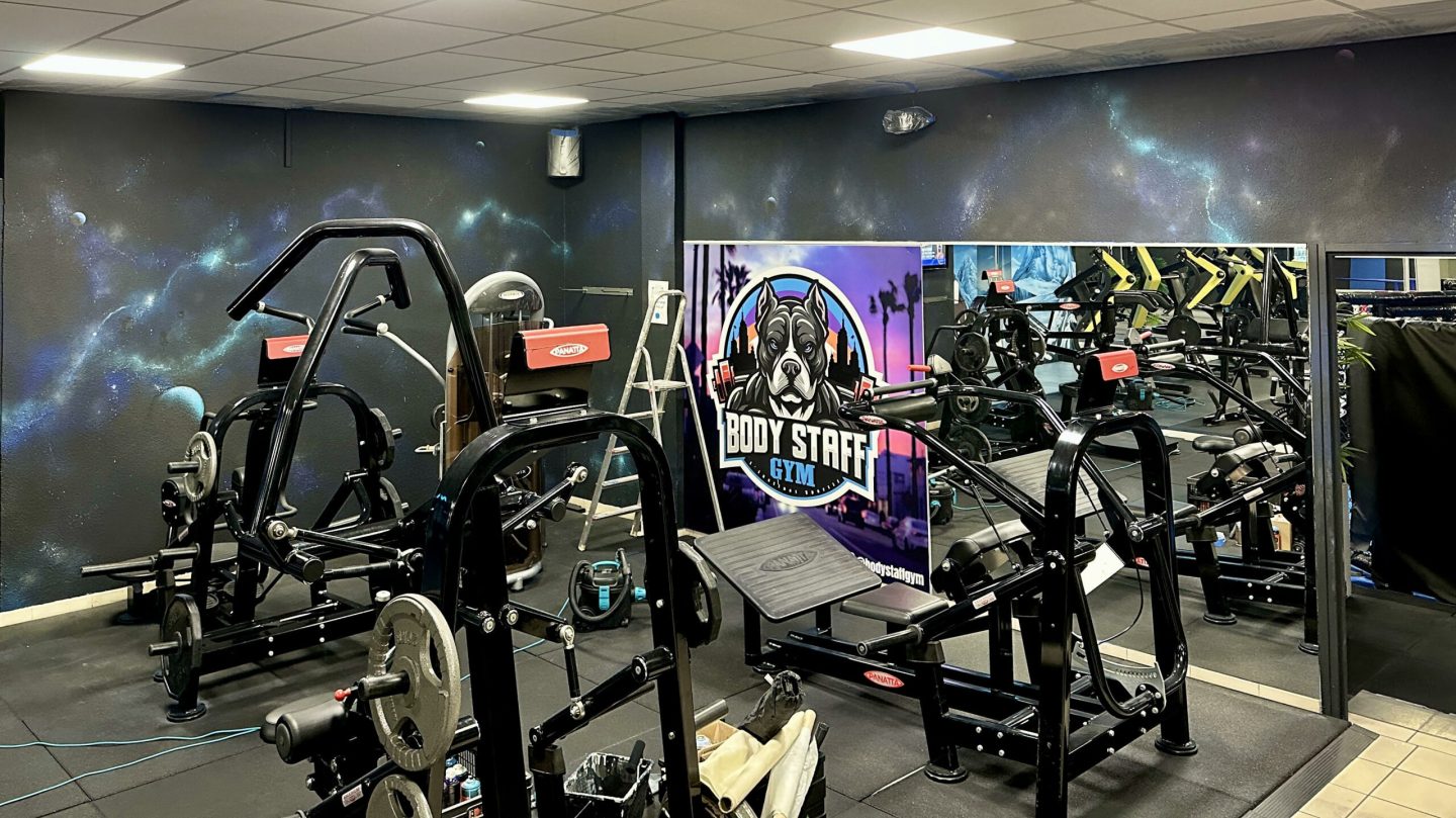 Mur décoré avec fresque cosmos et identité visuelle Body Staff Gym.
