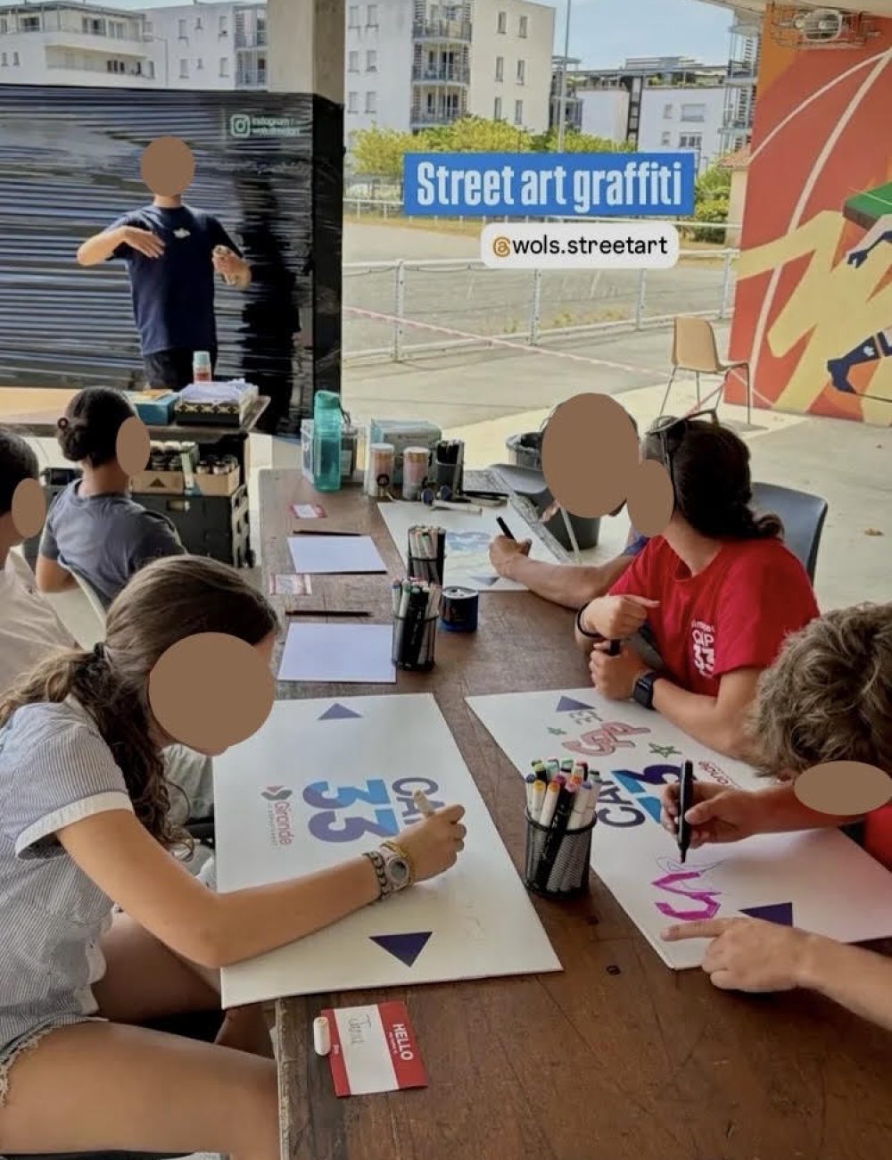 Participants dessinant leurs projets de graffiti lors d’un atelier WOLS Street Art pour CAP33 à Floirac.