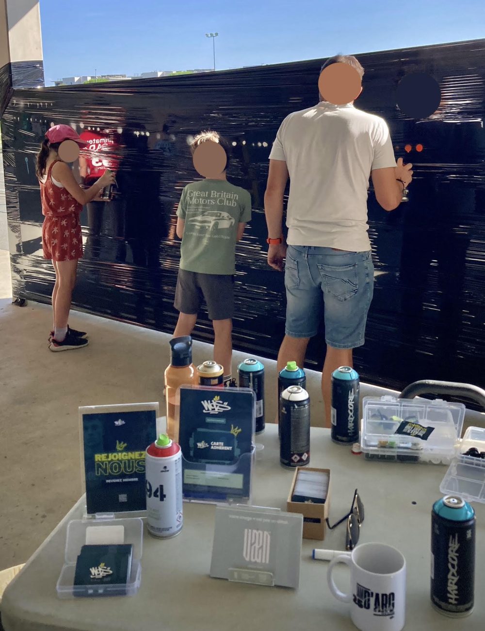 Adultes et enfants pratiquant le graffiti à la bombe lors d’un atelier WOLS Street Art pour CAP33 à Floirac.