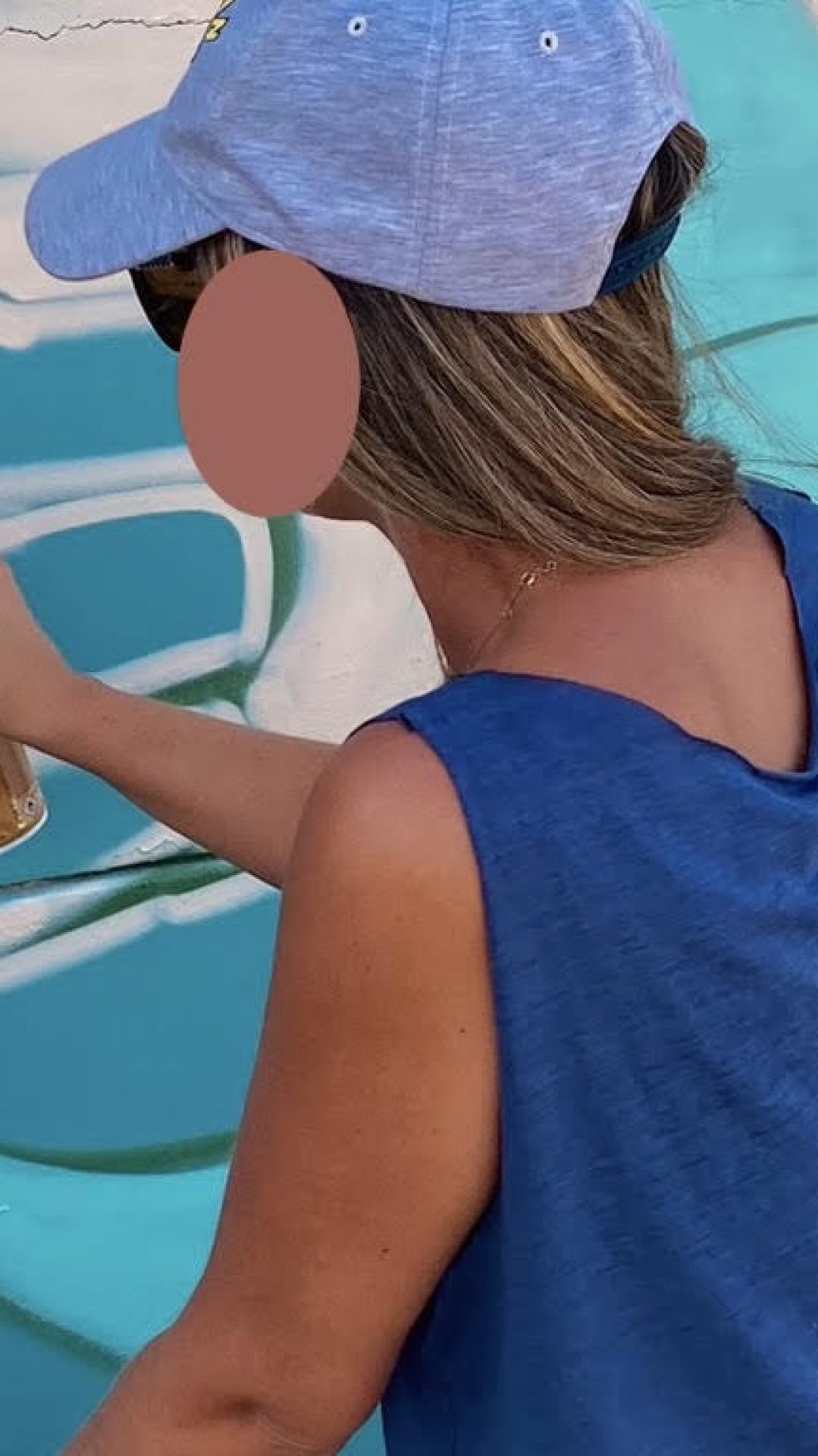 Participante peignant à la bombe les détails d'un personnage Bboy sur une fresque turquoise au stade Jean-Raymond Guyon.