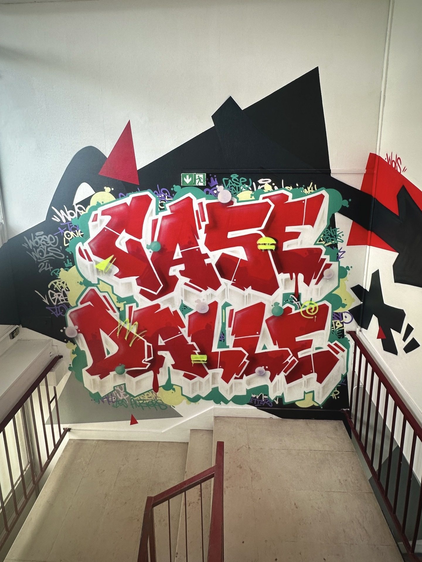 Vue complète de la fresque graffiti Case Dalle dans une cage d’escalier du quartier des Aubiers.