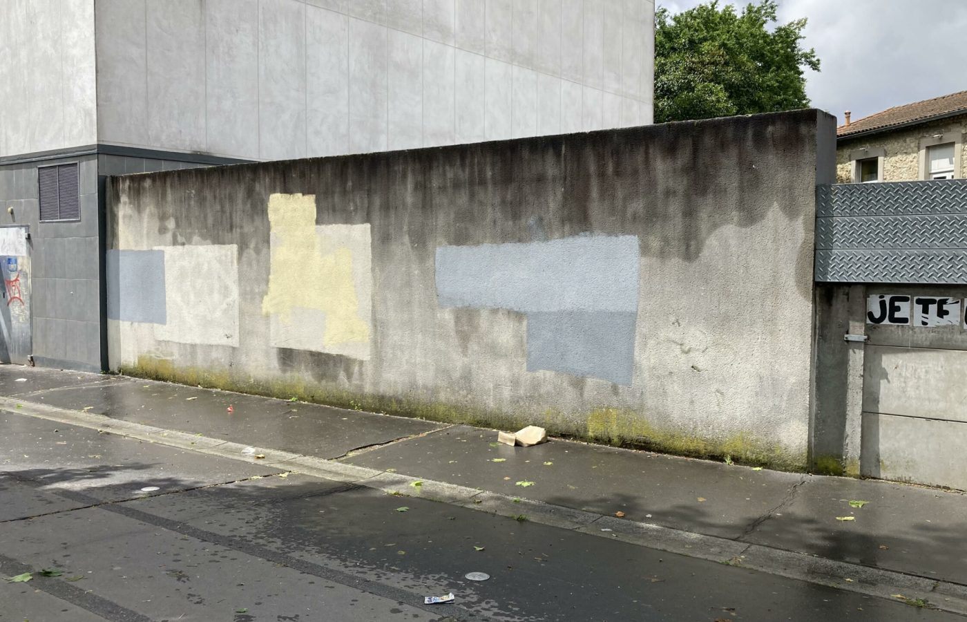 Mur extérieur avec traces de reprises de peinture avant réalisation d’une fresque graffiti à Cenon.