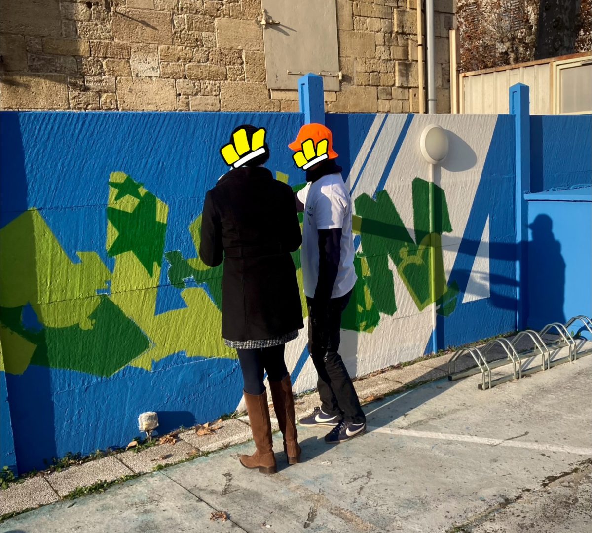Un artiste de l’association WOLS Street Art initie une passante au graffiti lors d’une fresque participative organisée avec Zolpan Bordeaux en décembre 2024.