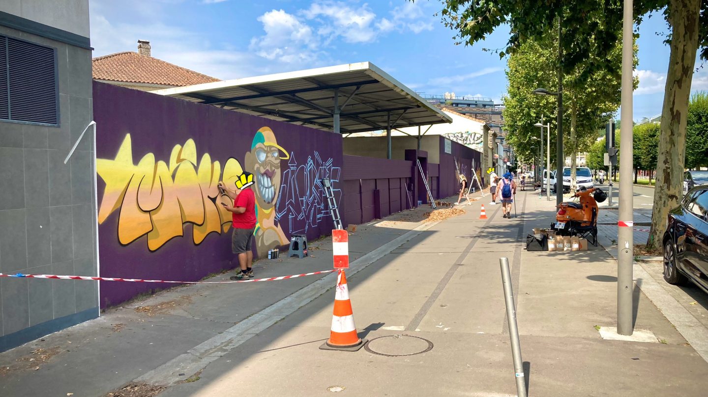 Artistes réalisant une fresque graffiti au petit matin lors de la JAM D'ARC 24 à Cenon.
