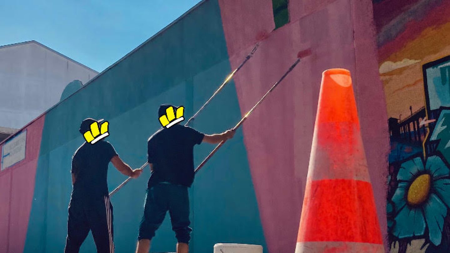 Artistes WOLS en train de peindre une fresque murale avec rouleaux sur un mur extérieur lors d’un projet de street art urbain