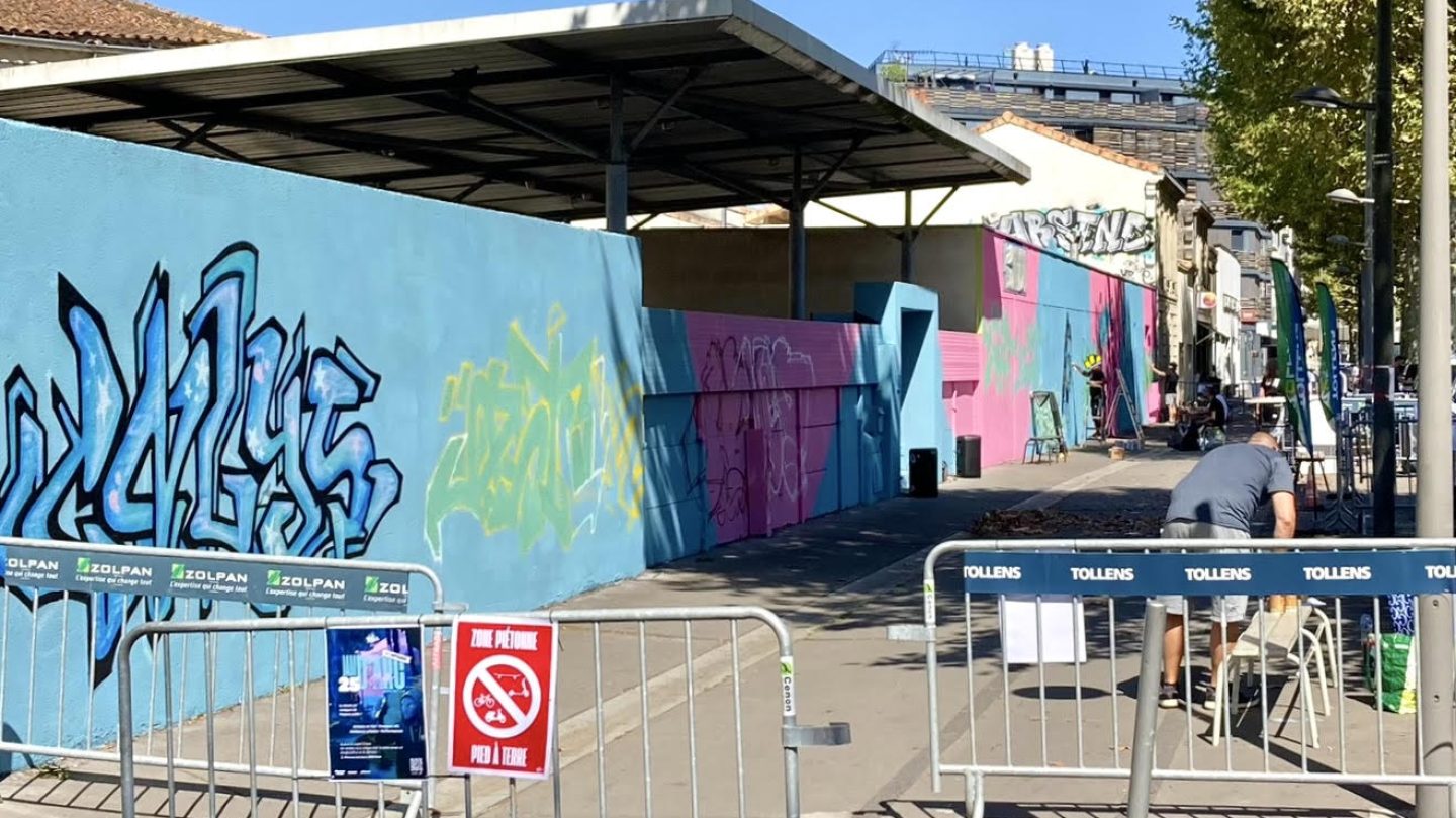 Vue générale du site de fresque murale à Cenon avec barrières de sécurité et mur en cours de peinture lors de la JAM D’ARC 25