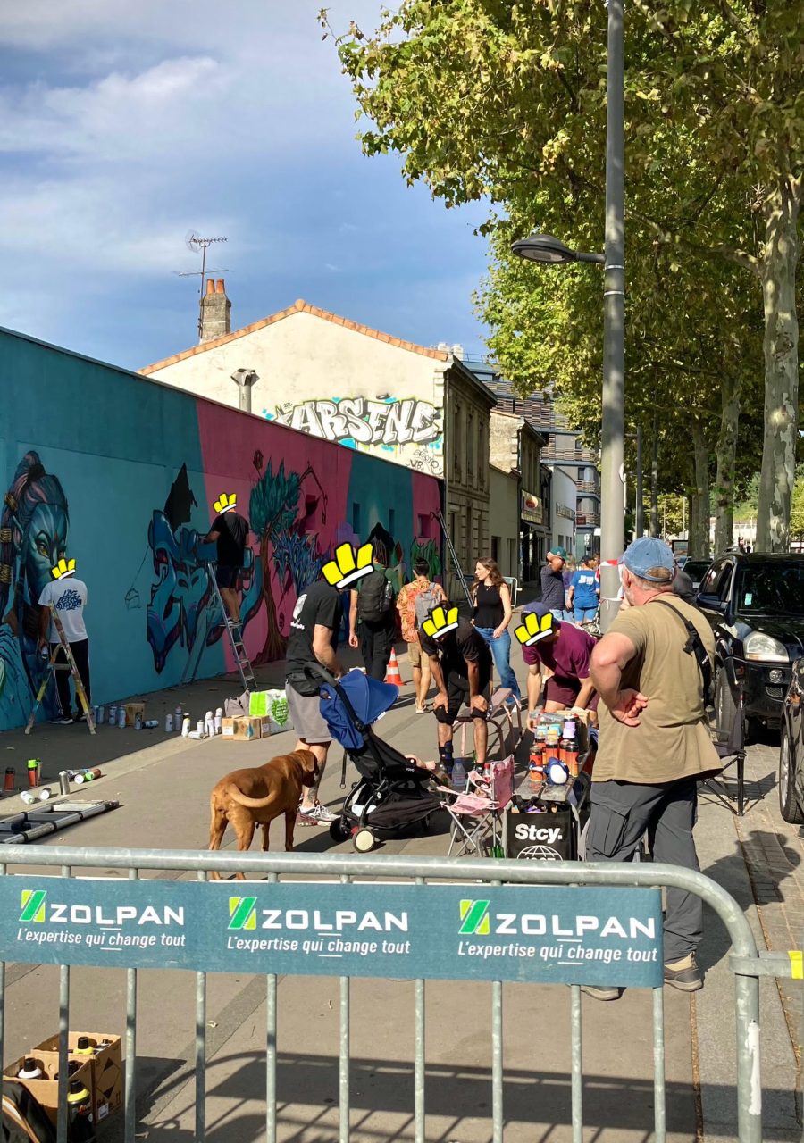 Artistes et public réunis autour d’une fresque graffiti en cours de création lors de la JAM D’ARC 2025.