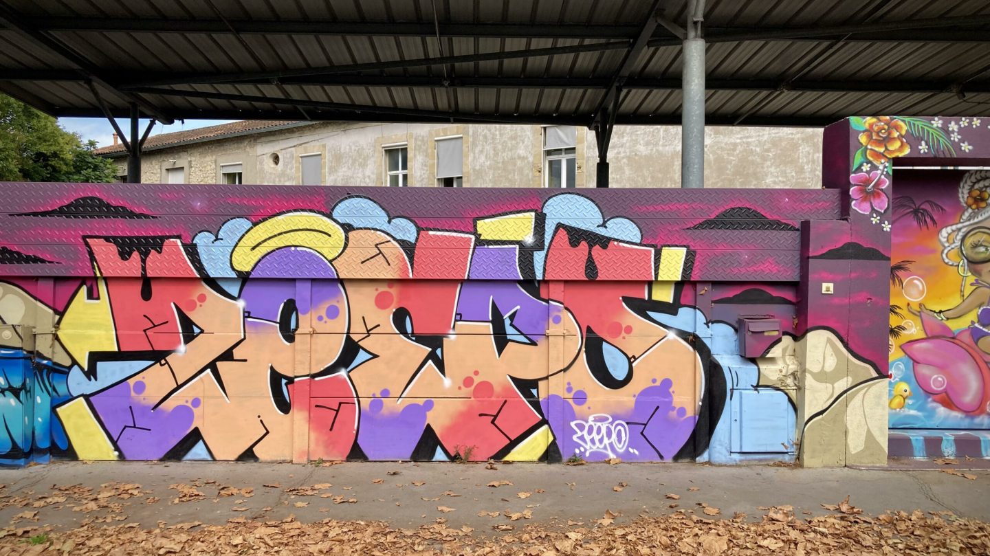 Lettrage graffiti coloré et fond dégradé rose et violet.