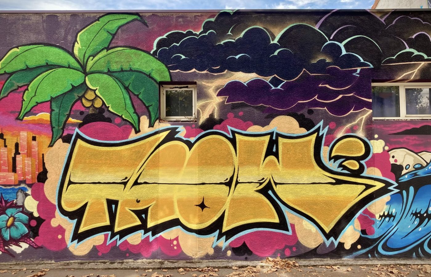 Lettrage graffiti doré avec nuages et éclairs en arrière-plan.