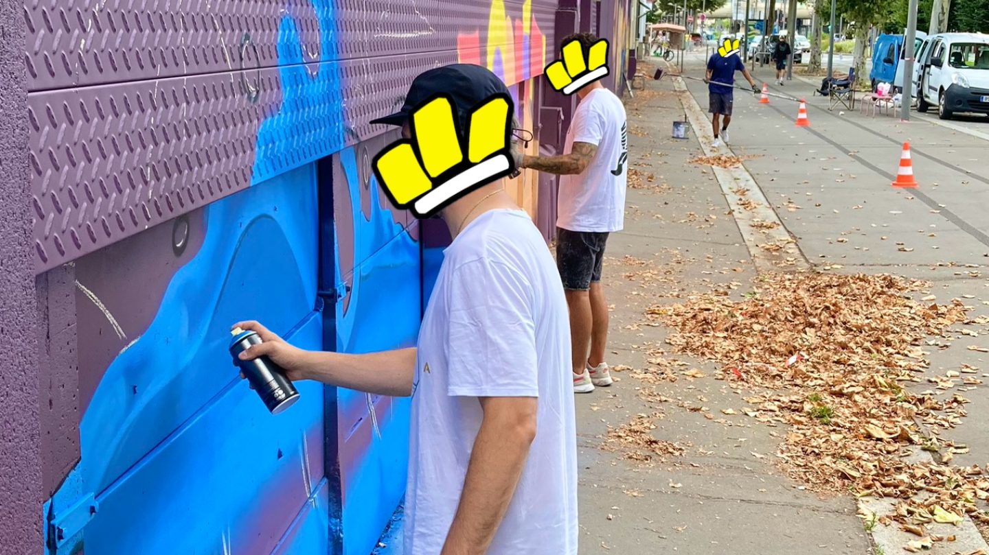 Plusieurs artistes réalisant une fresque graffiti sur un mur urbain à Cenon.