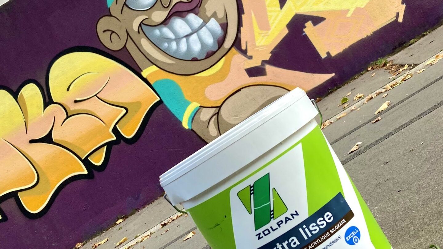 Seau de peinture Zolpan devant une fresque graffiti colorée à Cenon.