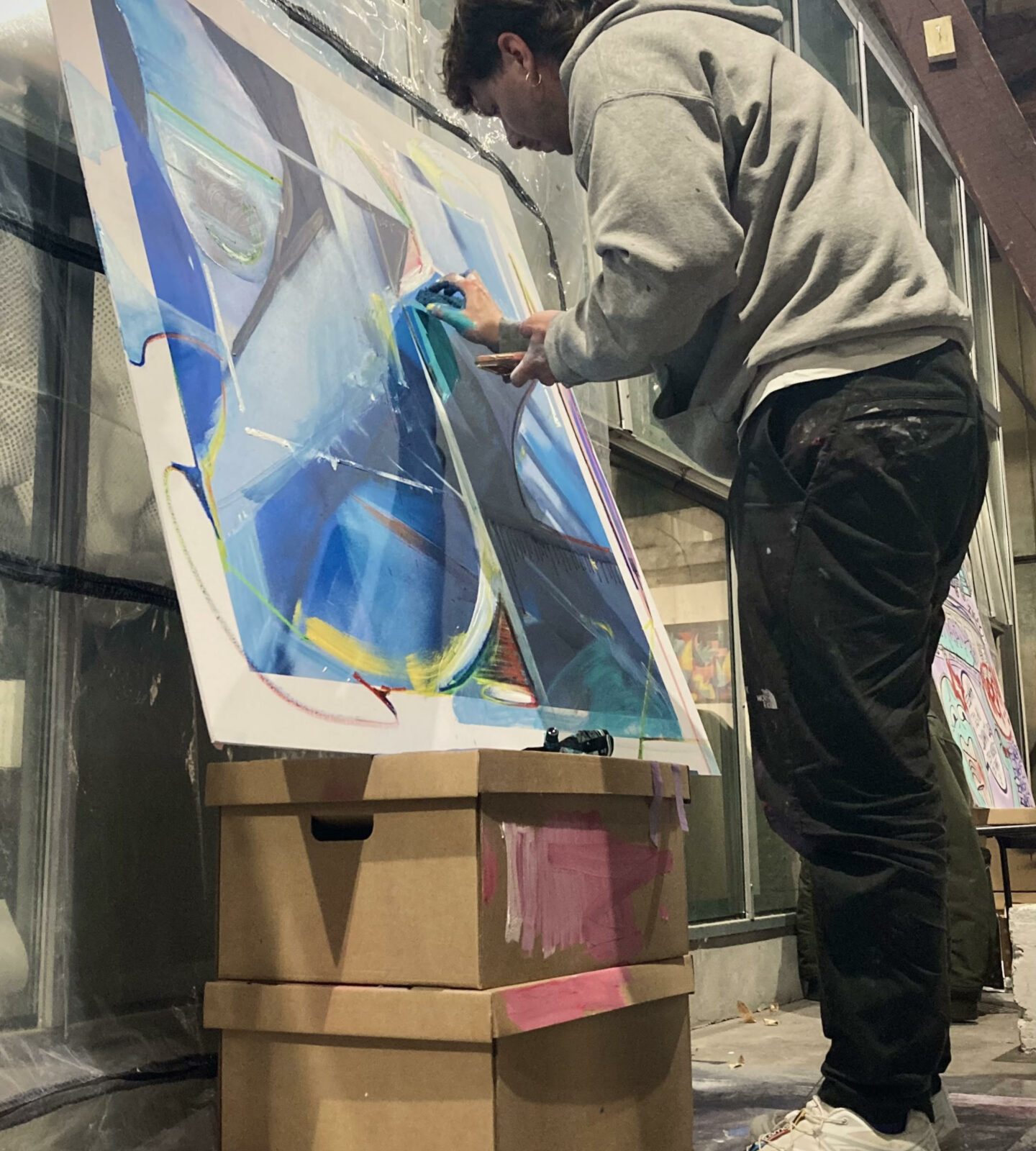 Artiste peignant une toile abstraite lors du battle street art du Prix ICART Bordeaux.
