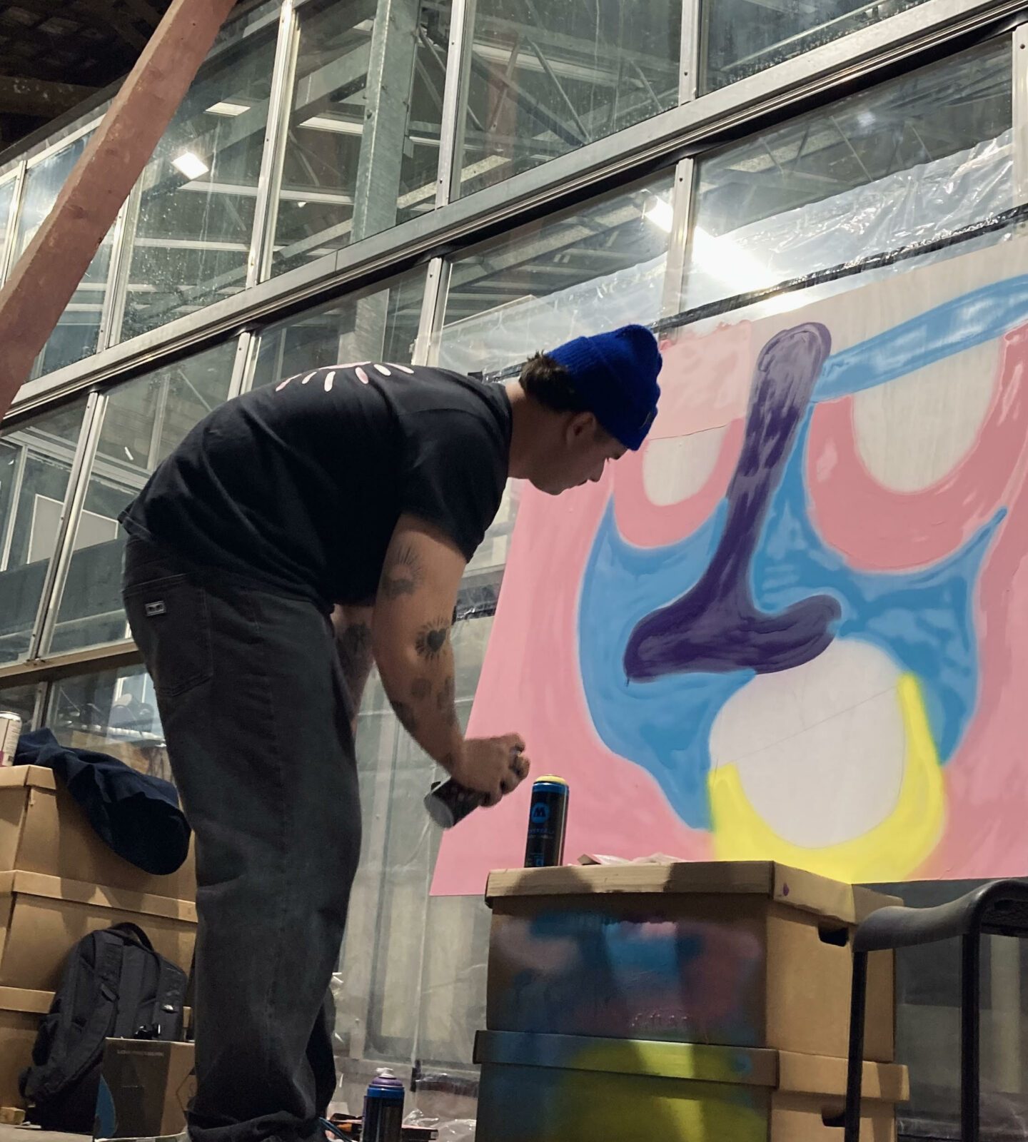 Artiste réalisant une peinture colorée à la bombe pendant le concours street art du Prix ICART Bordeaux.