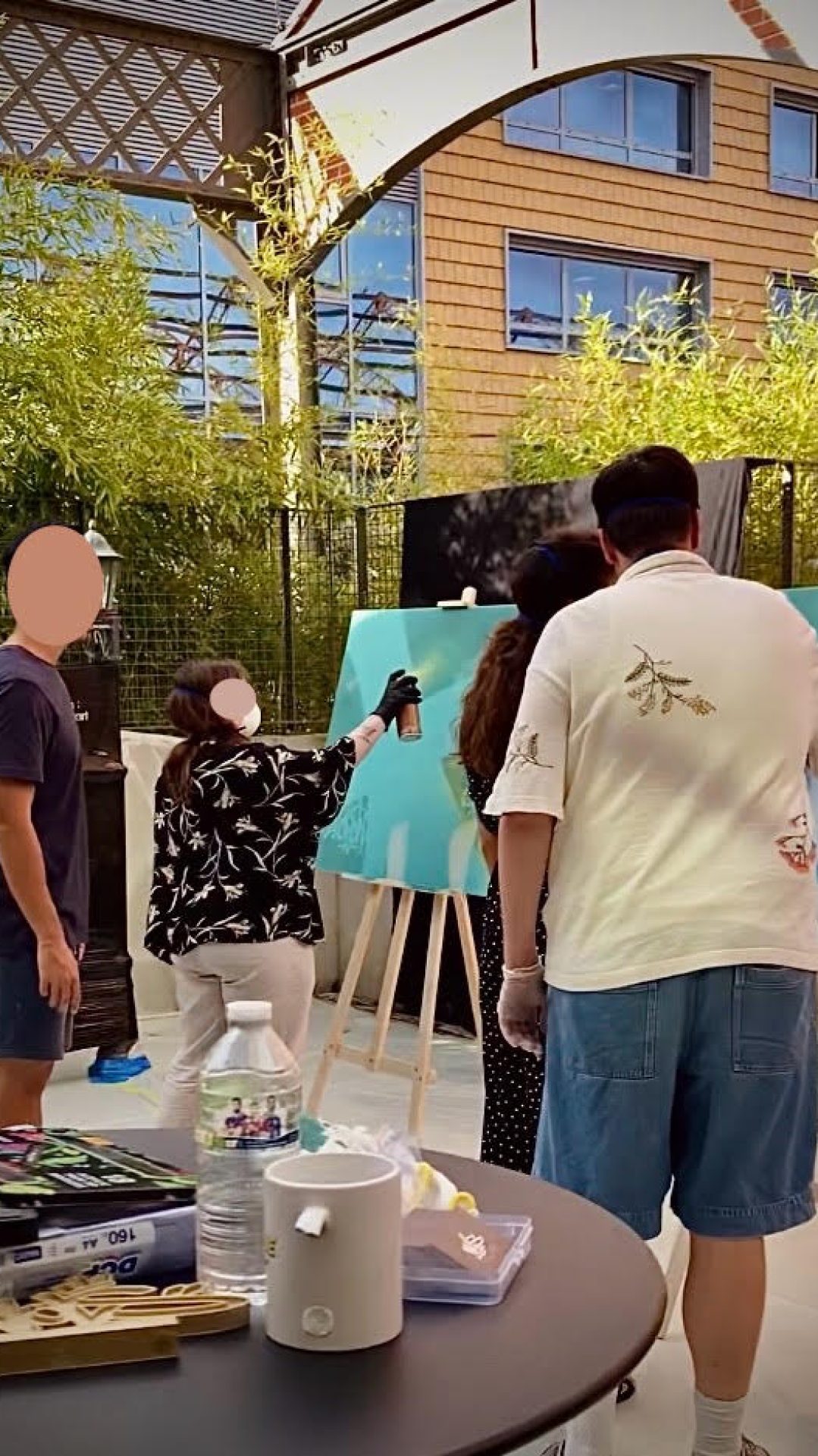 Employés d’Ubisoft Bordeaux peignant à la bombe sur des toiles lors d’un atelier graffiti collaboratif animé par WOLS Street Art.